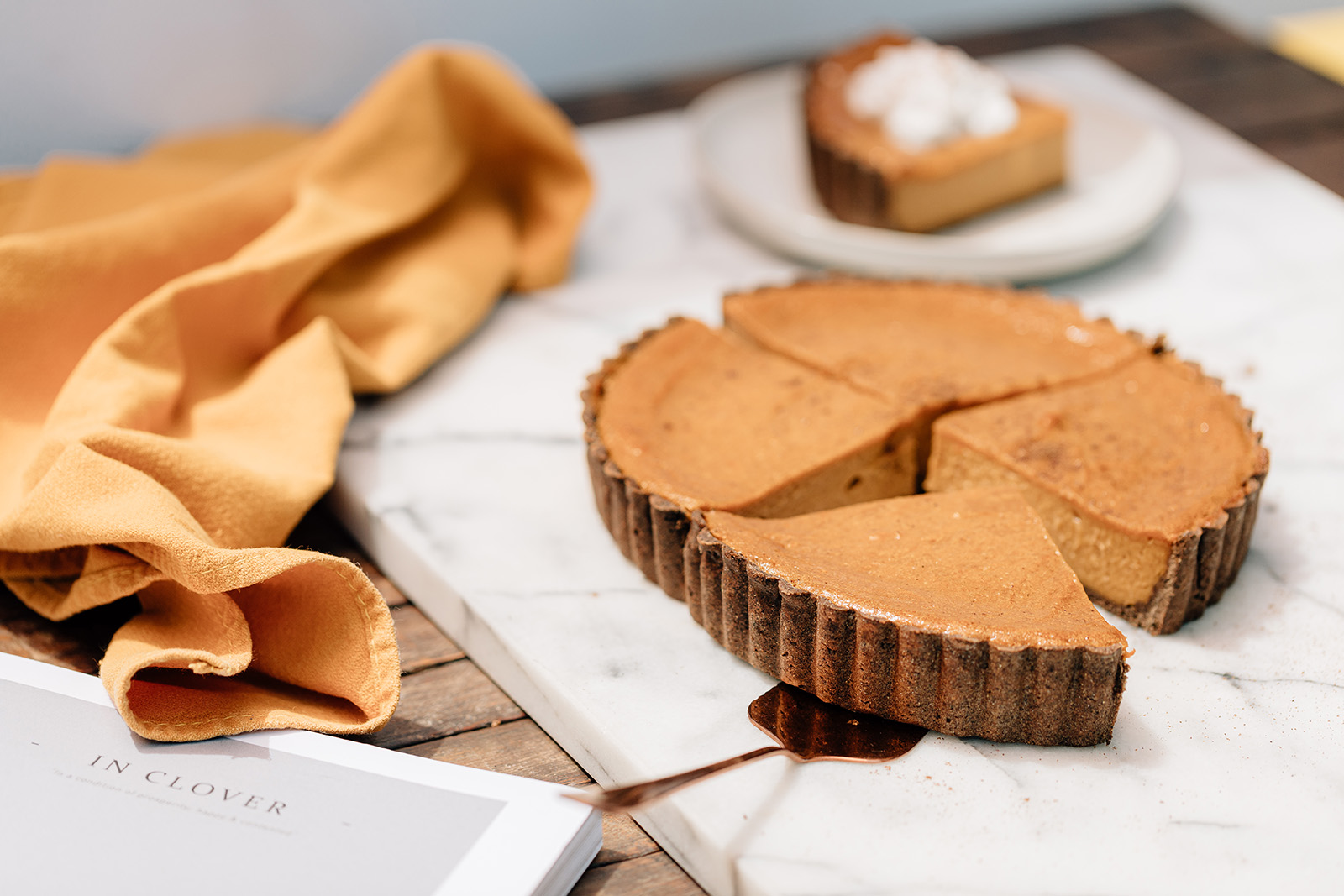 Squash Pie Filling Ingredients: 1. 4 cups roasted butternut squash (weight is final roasted weight) 2. ¼ cup evaporated cane sugar 3. ¼ cup brown sugar 4. 1 tsp. Kosher salt 5. 1 tsp. ground ginger 6. ½ tsp ground allspice 7. 1 tbsp. ground cinnamon 8. ½ tsp. ground nutmeg 9. 1 ¾ cup coconut cream 10. ⅓ cup cornstarch 11. 2 tbsp. brandy Method: 1. Cut squash in half from end to end and remove seeds. Place on parchment paper, cut side down, roast in a 325° oven for 45 to 60 minutes, until squash is tender. Remove skin. This is now the usable product weight. 2. Combine all ingredients in a large plastic container. 3. With an immersion blender, blend until completely smooth. 4. Pour mixture into a pre-set pie shell. 5. Bake at 325°F, low fan, for 22 minutes. Rotate the pan and continue to bake for 22 more minutes. 6. Bake pie until it reaches 175°F internal temperature. Let cool at room temperature for 1 hour. Squash Pie Graham Pie Dough Ingredients: 1. ¾ cup gluten-free flour (Bob's Red Mill) 2. ½ cup buckwheat flour 3. ½ tsp. baking soda 4. 2 tsp. ground cinnamon 5. 1 pinch Kosher salt 6. ½ cup evaporated cane sugar 7. 3 tbsp. coconut oil (melted) 8. ¼ cup water 9. 1 tsp. vanilla bean paste Method: 1. Combine oat flour, buckwheat flour, baking soda, cinnamon, salt and sugar, mix well. 2. Add coconut oil, water and vanilla paste. Mix until dough starts to come together. 3. Scrape sides of bowl and continue mixing until dough is smooth and consistent. 4. Roll between 2 sheets of parchment paper until it’s slightly bigger than pie mold. 5. Dust rolling pin with gluten free flour before using to pick up and transfer to pie mold. 6. Lightly brush mold with oil. 7. Press dough into pie mold evenly, then dock dough with a fork. 8. Chill dough for at least 30 minutes before baking. This story is from the Fall 2021 issue. Read the magazine here.