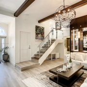 Maura Rossi, an accomplished interior designer, standing in a stylishly decorated living room she designed, exemplifying her elegant and innovative aesthetic.