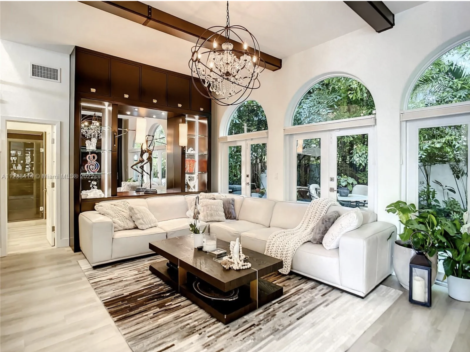 Maura Rossi, an accomplished interior designer, standing in a stylishly decorated living room she designed, exemplifying her elegant and innovative aesthetic.