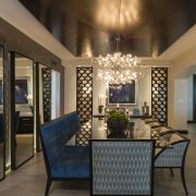 Maura Rossi, an accomplished interior designer, standing in a stylishly decorated living room she designed, exemplifying her elegant and innovative aesthetic.