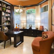 Maura Rossi, an accomplished interior designer, standing in a stylishly decorated living room she designed, exemplifying her elegant and innovative aesthetic.