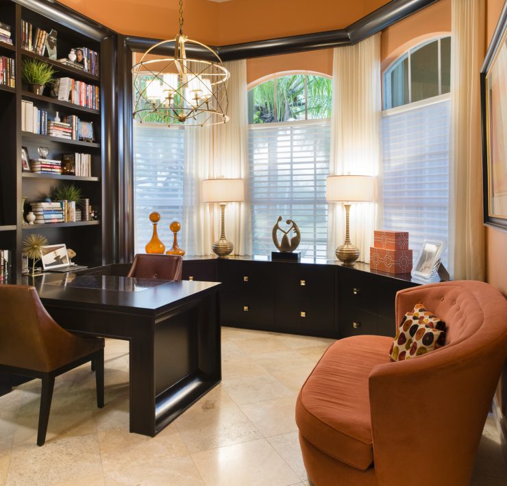 Maura Rossi, an accomplished interior designer, standing in a stylishly decorated living room she designed, exemplifying her elegant and innovative aesthetic.