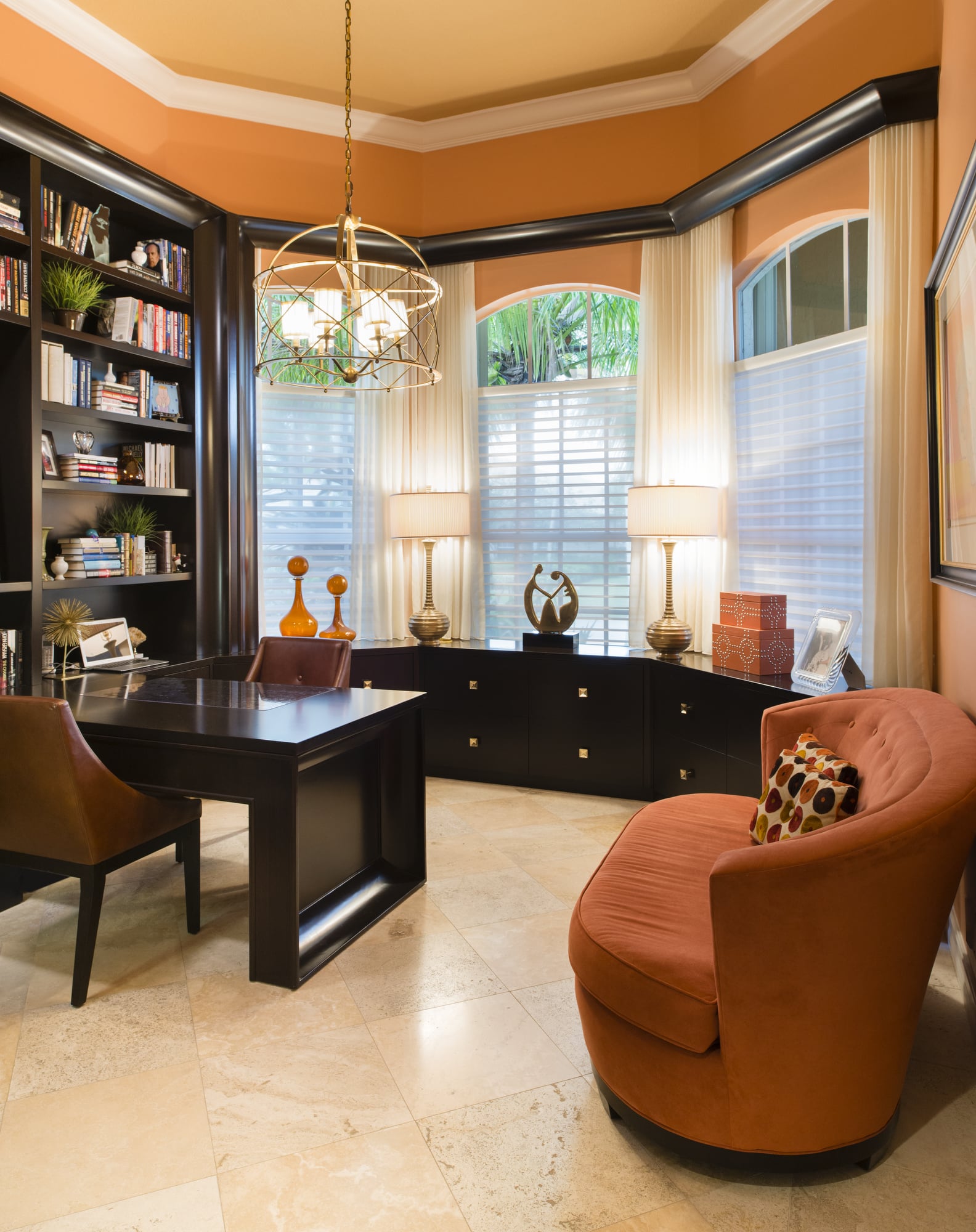 Maura Rossi, an accomplished interior designer, standing in a stylishly decorated living room she designed, exemplifying her elegant and innovative aesthetic.