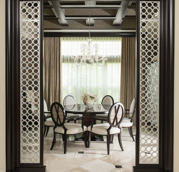 Maura Rossi, an accomplished interior designer, standing in a stylishly decorated living room she designed, exemplifying her elegant and innovative aesthetic.