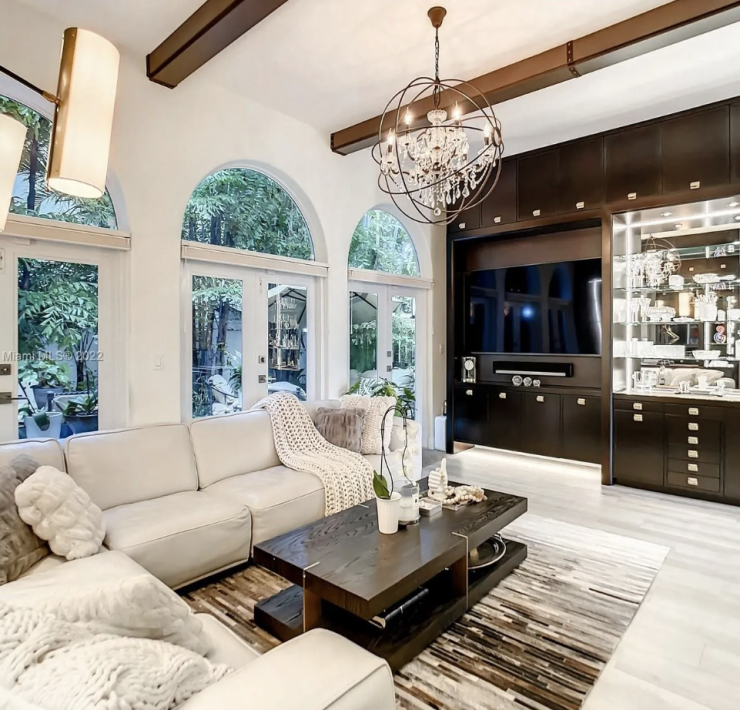 Maura Rossi, an accomplished interior designer, standing in a stylishly decorated living room she designed, exemplifying her elegant and innovative aesthetic.