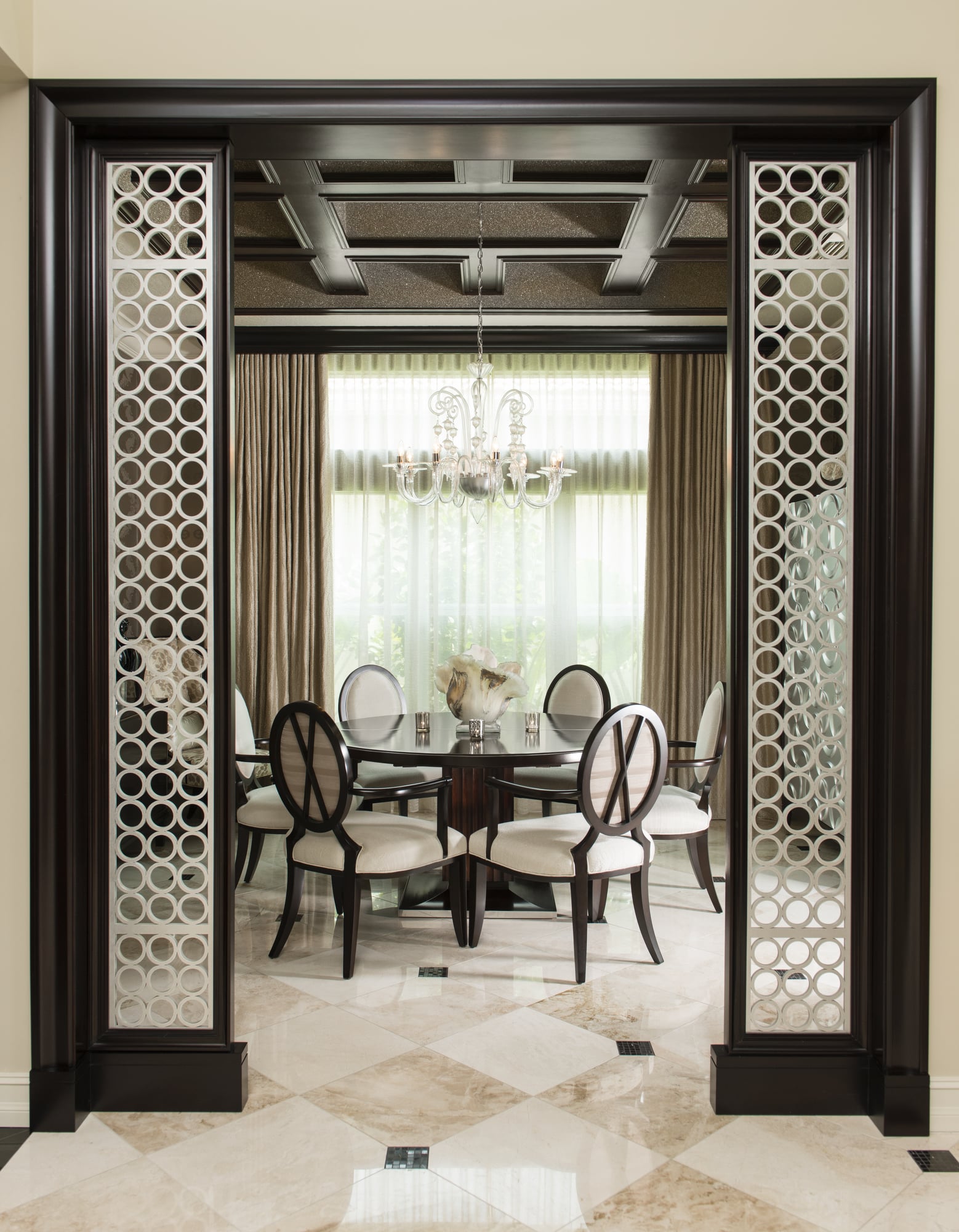 Maura Rossi, an accomplished interior designer, standing in a stylishly decorated living room she designed, exemplifying her elegant and innovative aesthetic.