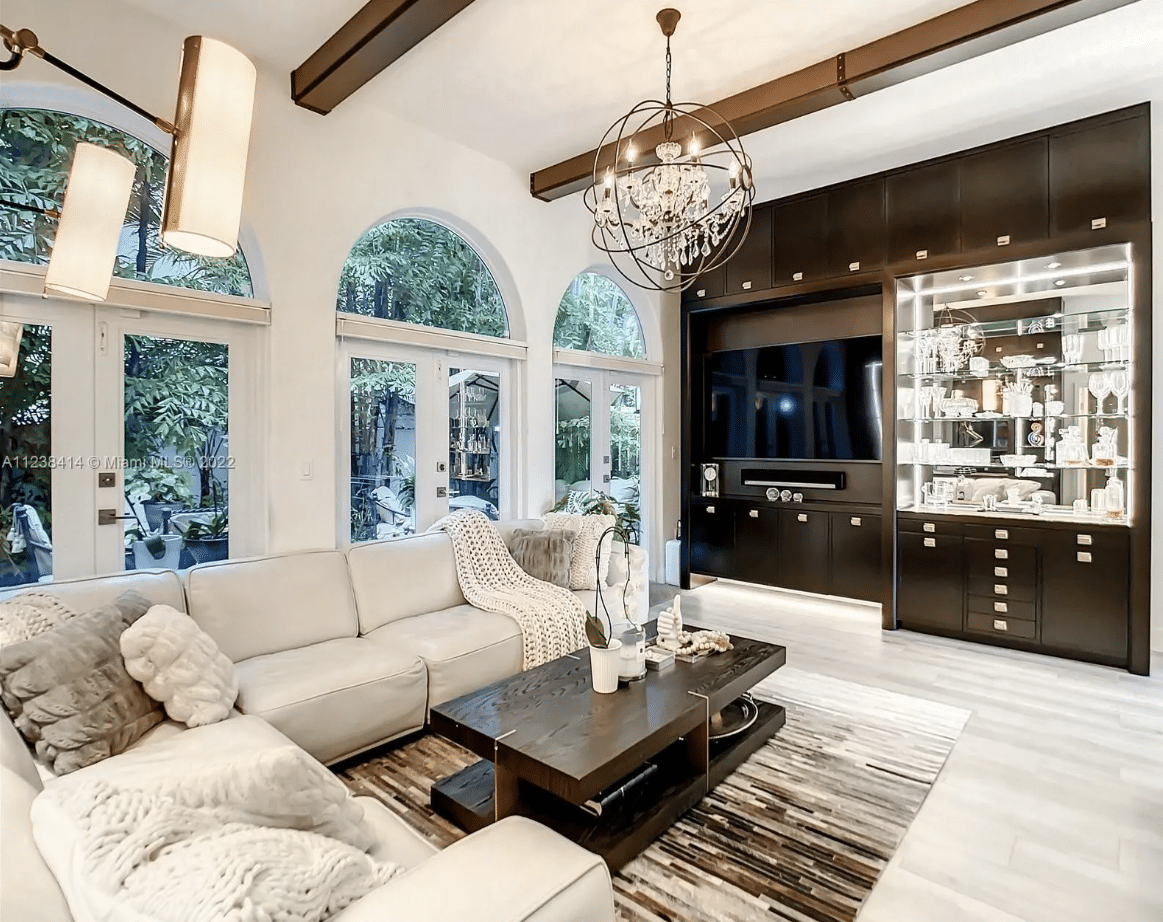 Maura Rossi, an accomplished interior designer, standing in a stylishly decorated living room she designed, exemplifying her elegant and innovative aesthetic.