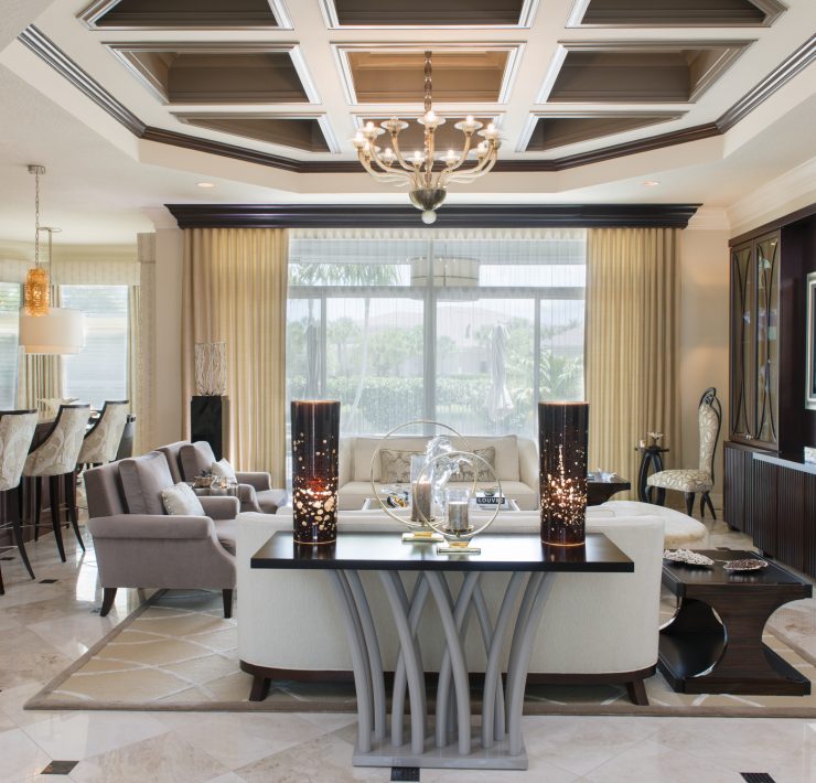 Maura Rossi, an accomplished interior designer, standing in a stylishly decorated living room she designed, exemplifying her elegant and innovative aesthetic.