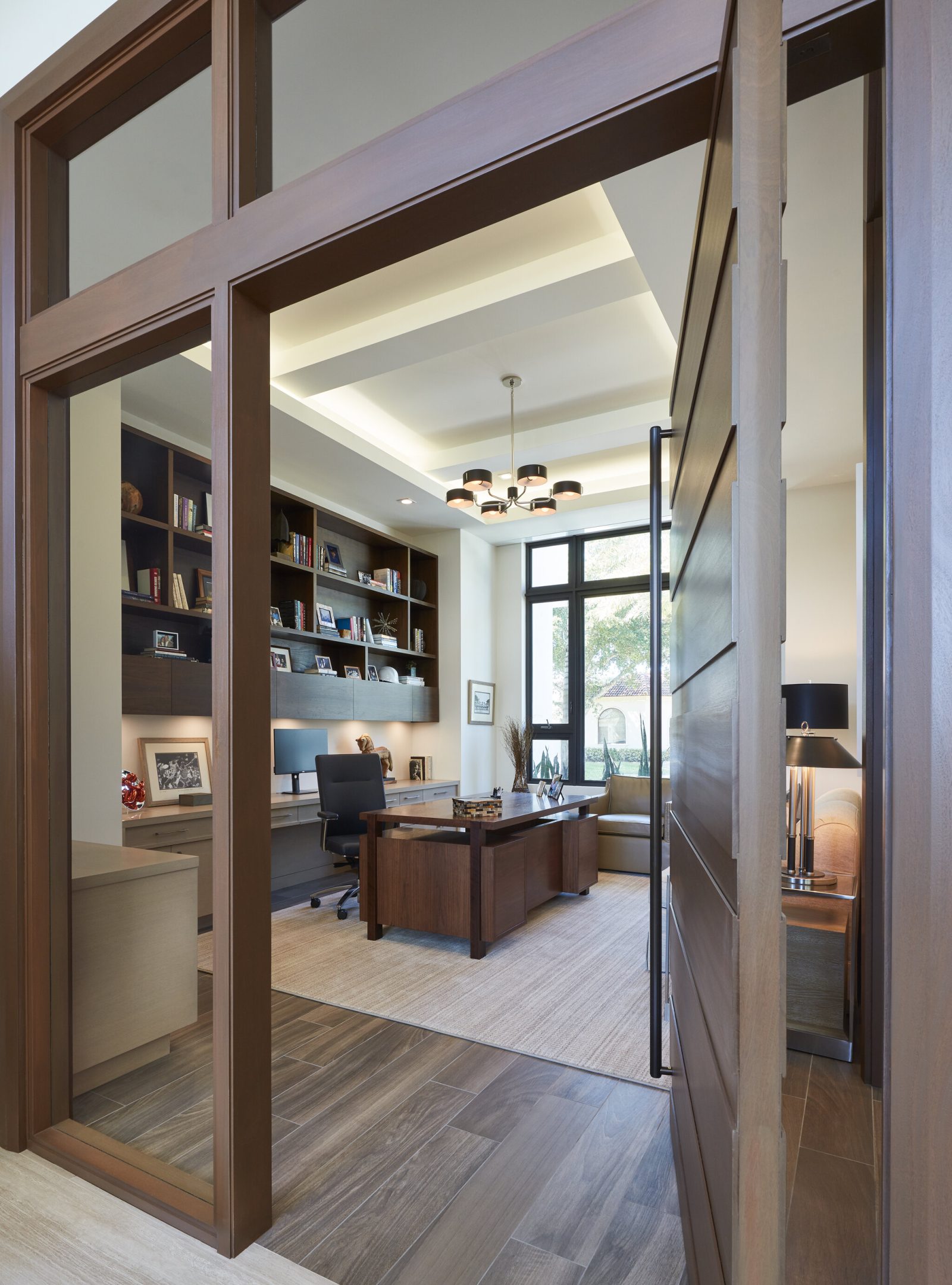 Gage Hartung, a professional and focused interior designer, reviewing blueprints and fabric samples in his well-organized office, surrounded by elegant and modern design elements.