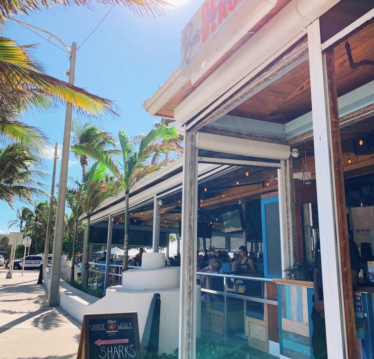 Front view of Bo’s Beach in Fort Lauderdale, a beachfront restaurant with a tropical vibe, open-air terrace, and palm trees under the Florida sun.