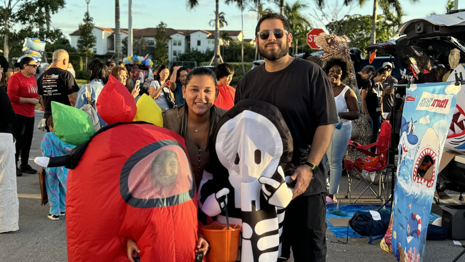 Families in creative costumes enjoying Miami Beach’s Halloween block party under the palm trees.