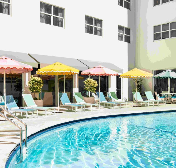 Retro-inspired pool area at The Catalina Hotel featuring pastel umbrellas and sun loungers. Caption: Playful colors and vintage flair define The Catalina Hotel’s iconic Miami Beach poolside experience.