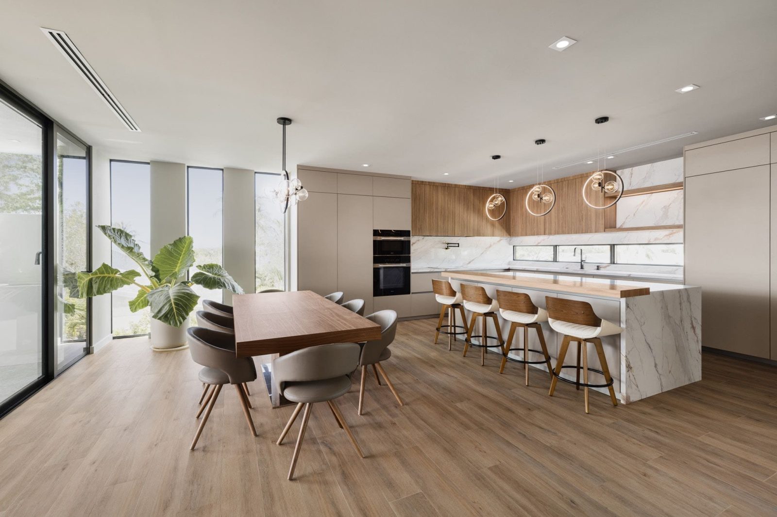 Modern open-concept kitchen and dining area inside the $7.3M Key Largo bayfront villa featuring wood floors, minimalist design, and panoramic ocean views.