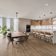Modern open-concept kitchen and dining area inside the $7.3M Key Largo bayfront villa featuring wood floors, minimalist design, and panoramic ocean views.