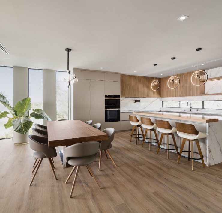 Modern open-concept kitchen and dining area inside the $7.3M Key Largo bayfront villa featuring wood floors, minimalist design, and panoramic ocean views.