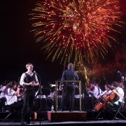 Outdoor symphony performance in Miami Beach with fireworks lighting up the sky during Fall for the Arts cultural season.