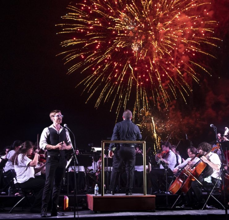 Outdoor symphony performance in Miami Beach with fireworks lighting up the sky during Fall for the Arts cultural season.