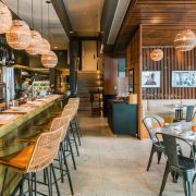 The Alley bar at The Betsy Hotel Miami Beach featuring warm lighting, modern wood design, and rattan seating.