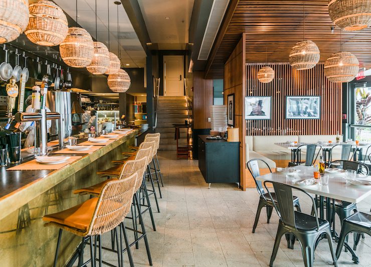 The Alley bar at The Betsy Hotel Miami Beach featuring warm lighting, modern wood design, and rattan seating.