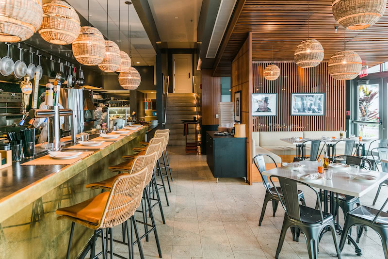 The Alley bar at The Betsy Hotel Miami Beach featuring warm lighting, modern wood design, and rattan seating.