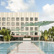 Rooftop pool area at The Goodtime Hotel Miami with palm trees and pastel tones. Caption: The Goodtime Hotel’s rooftop pool captures Miami’s sun-drenched, carefree spirit.