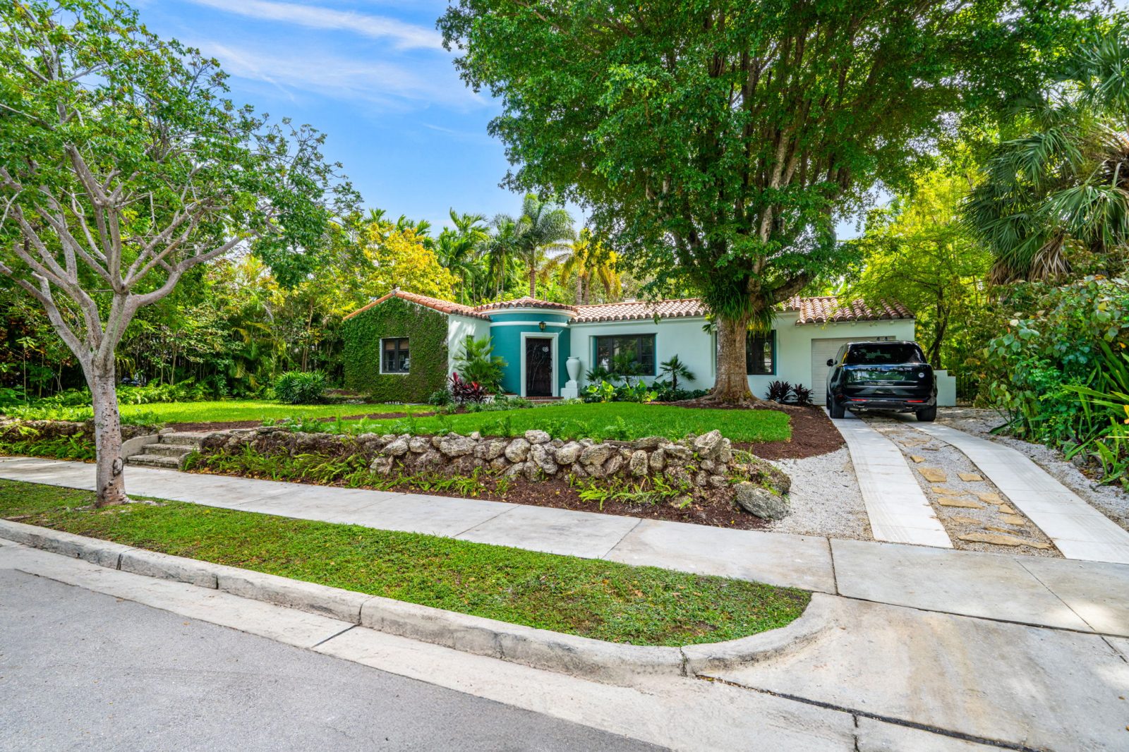 Exterior view of the tropical Art Deco home by Victor Nellenbogen in Belle Meade, surrounded by lush greenery.