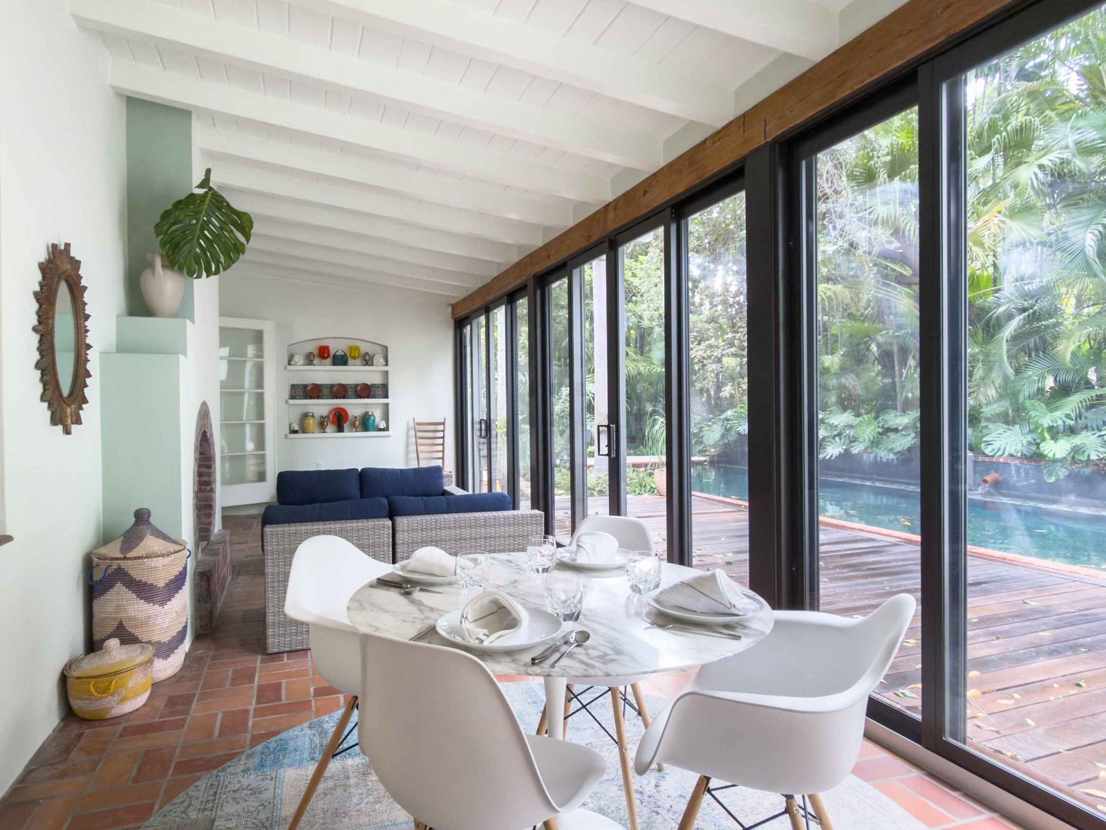 Dining area with floor-to-ceiling windows in the Victor Nellenbogen–designed tropical Deco home in Belle Meade, Miami.
