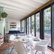 Dining area with floor-to-ceiling windows in the Victor Nellenbogen–designed tropical Deco home in Belle Meade, Miami.