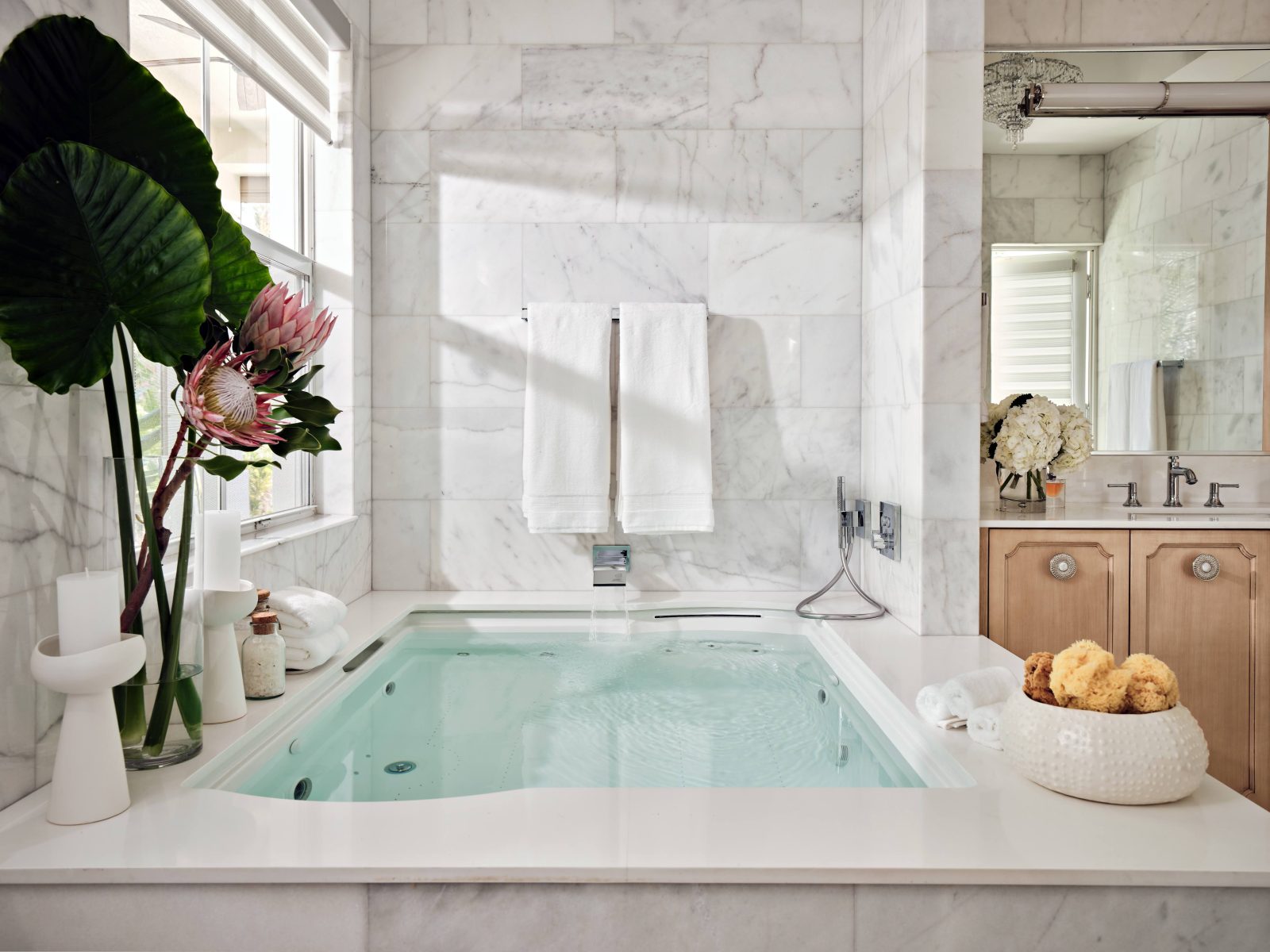 Ensuite bathroom with soaking tub, marble surfaces, and wood cabinetry designed by Maritza Capiro.