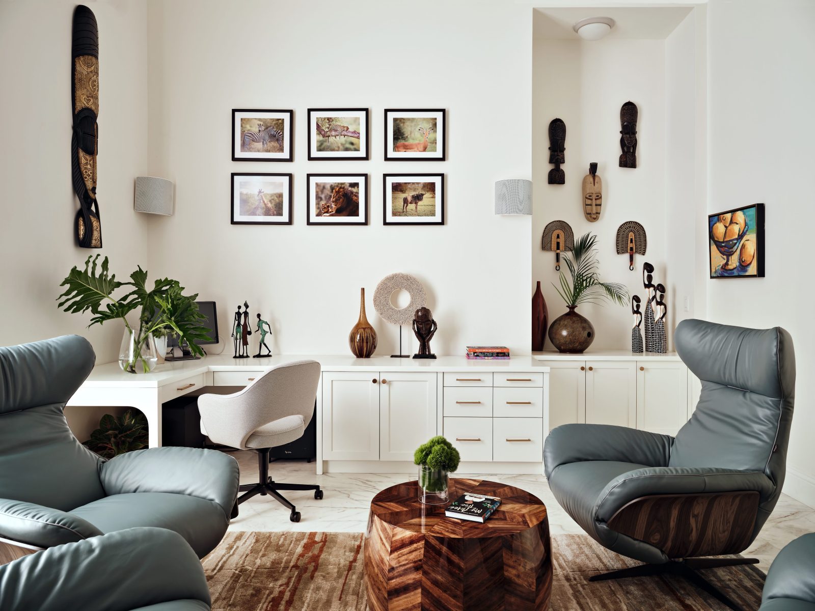 Contemporary home office with gallery wall, blue chairs, and eclectic decor by Maritza Capiro.