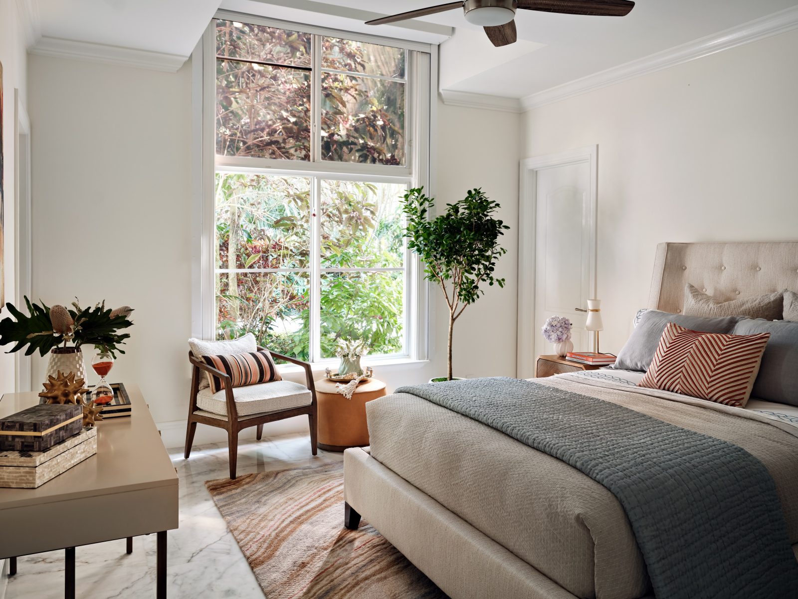 Calming bedroom featuring layered textures, light wood tones, and elegant soft furnishings.