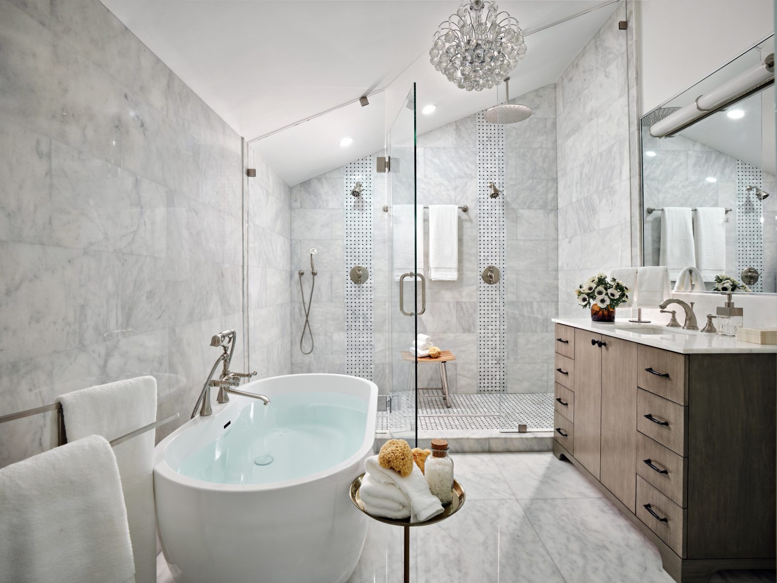 Luxury bathroom with freestanding tub, marble walls, and glass shower enclosure by Maritza Capiro.