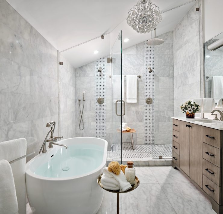 Luxury bathroom with freestanding tub, marble walls, and glass shower enclosure by Maritza Capiro.