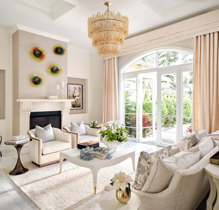 Bright sitting area with large windows, artwork, and layered textures creating a cozy atmosphere