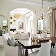 Dining room with statement chandelier, coffered ceiling, and neutral tones designed by Maritza Capiro.