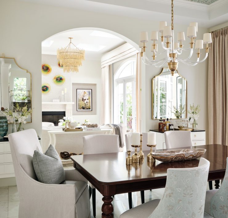 Dining room with statement chandelier, coffered ceiling, and neutral tones designed by Maritza Capiro.