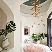 “Elegant foyer with sculptural chandelier, marble floors, and arched entry designed by Maritza Capiro