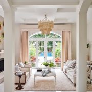 Sophisticated living room with neutral palette, French doors, and chandelier by Maritza Capiro.
