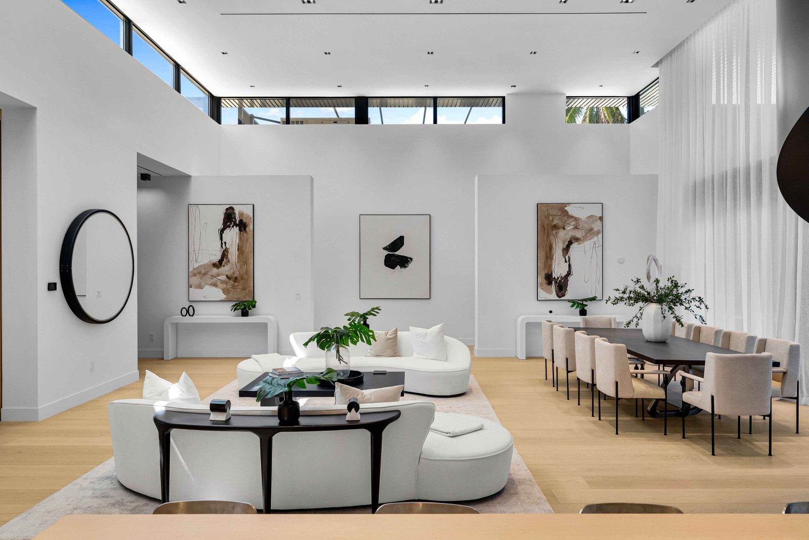 Spacious modern living room with minimalist decor, white walls, and floor-to-ceiling windows in a Golden Beach luxury home.