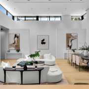 Spacious modern living room with minimalist decor, white walls, and floor-to-ceiling windows in a Golden Beach luxury home.