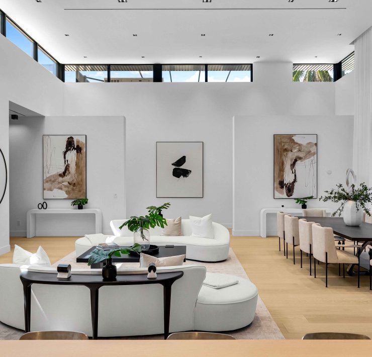 Spacious modern living room with minimalist decor, white walls, and floor-to-ceiling windows in a Golden Beach luxury home.