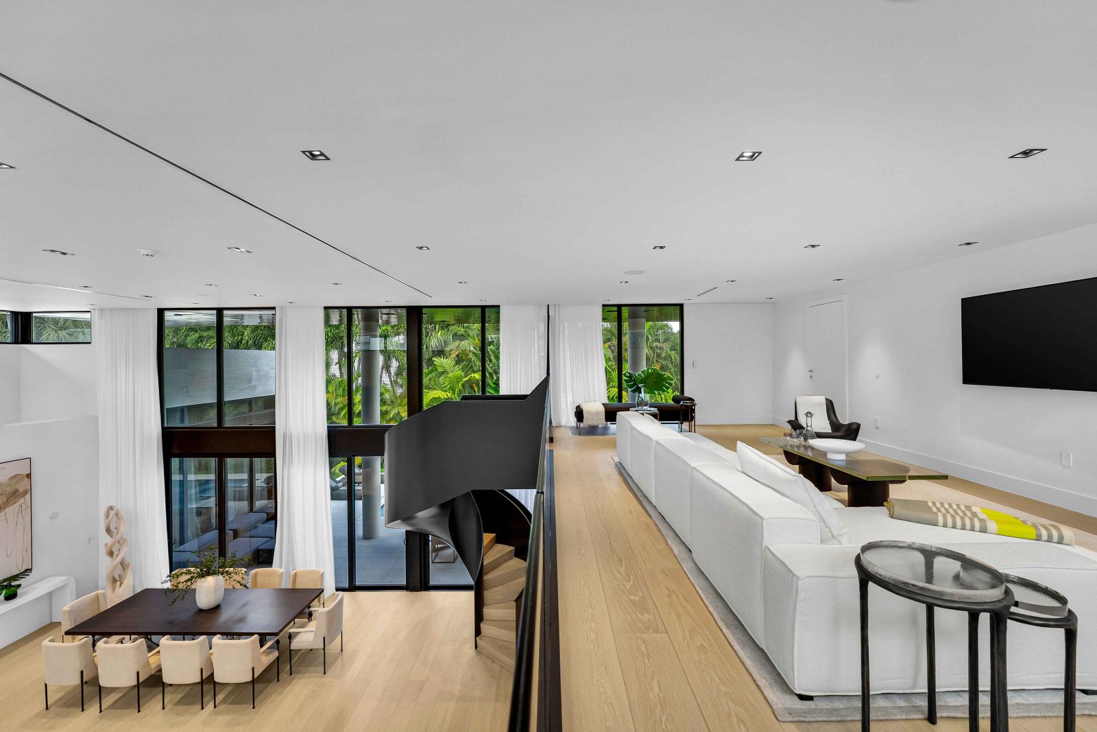 Interior view of the Golden Beach luxury home showcasing the floating mezzanine and custom black steel staircase overlooking the living area.