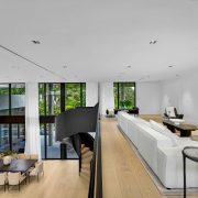 Interior view of the Golden Beach luxury home showcasing the floating mezzanine and custom black steel staircase overlooking the living area.