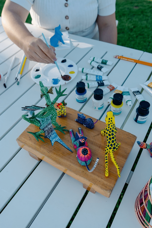 Guest painting colorful alebrijes during a traditional Mexican art workshop at Mar del Cabo
