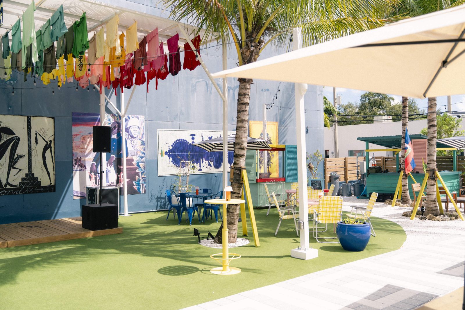 Outdoor courtyard at Lakou Miami in Little Haiti, featuring colorful seating, art installations, and a lively tropical ambiance.