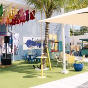 Outdoor courtyard at Lakou Miami in Little Haiti, featuring colorful seating, art installations, and a lively tropical ambiance.