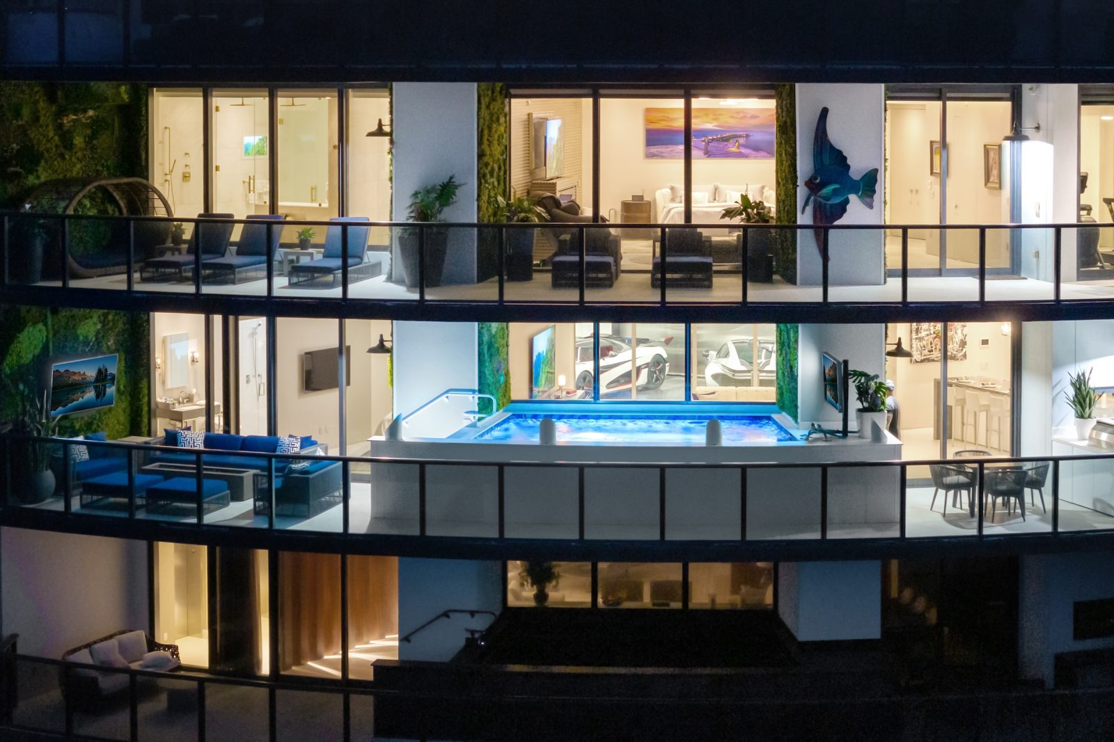 Exterior night view of Porsche Design Tower Penthouse 4405 showing illuminated terrace and double-level design in Sunny Isles Beach.
