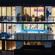 Exterior night view of Porsche Design Tower Penthouse 4405 showing illuminated terrace and double-level design in Sunny Isles Beach.