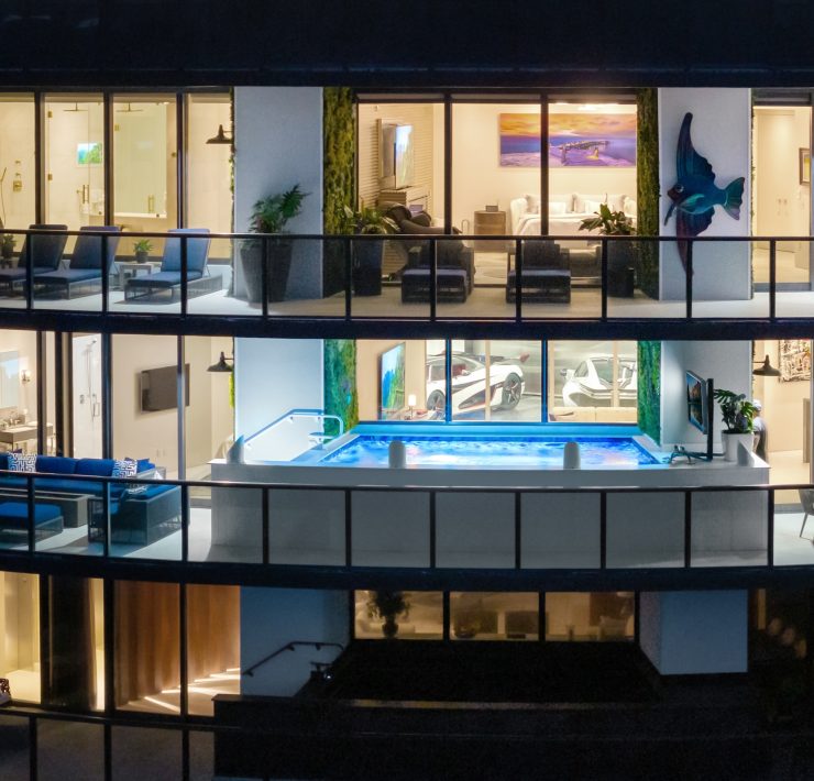 Exterior night view of Porsche Design Tower Penthouse 4405 showing illuminated terrace and double-level design in Sunny Isles Beach.