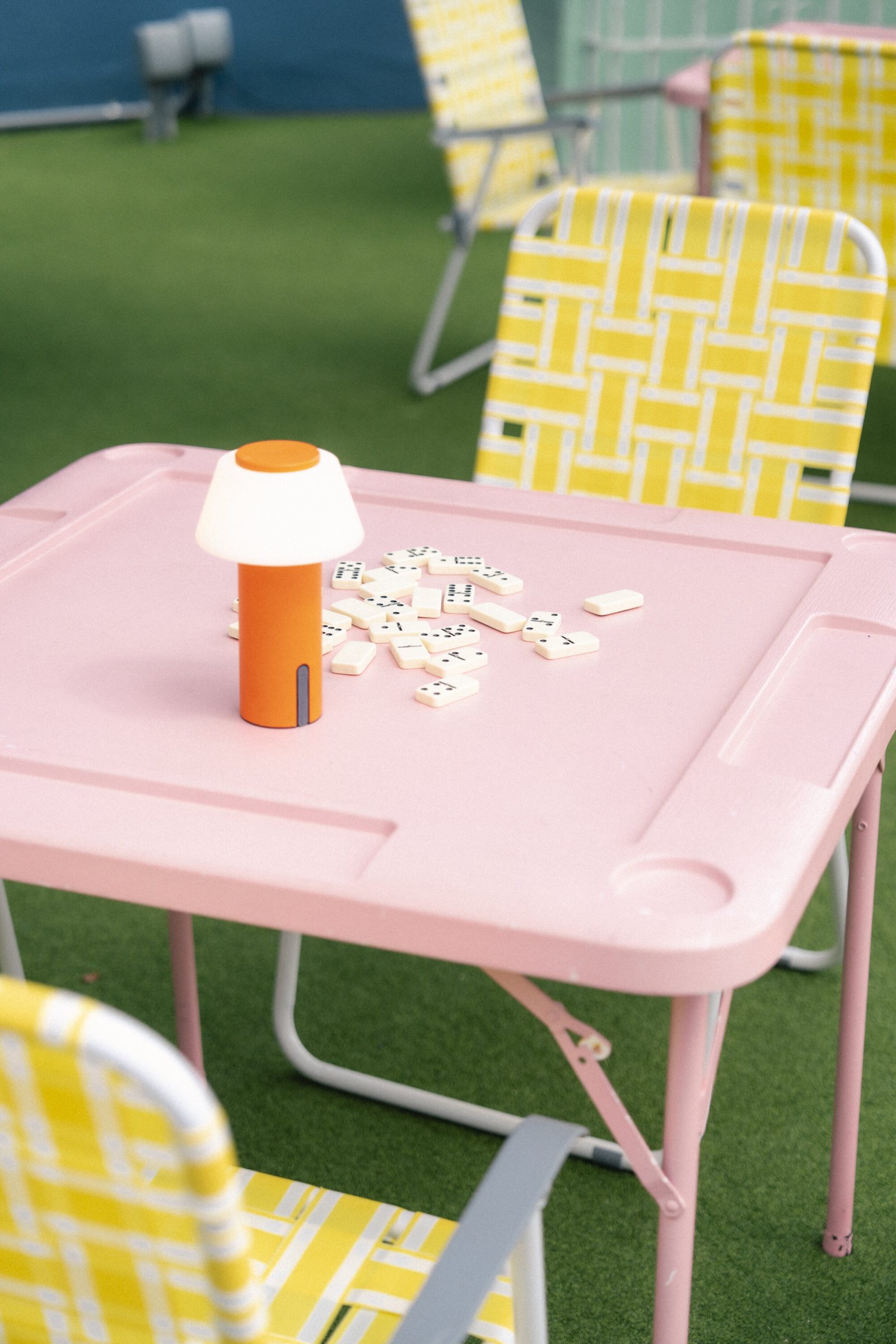 Pink domino table setup at Lakou Miami’s outdoor lounge, featuring playful decor and vibrant Caribbean-inspired design in Little Haiti.